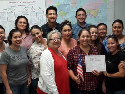 students surrounding a fellow student holding a certificate