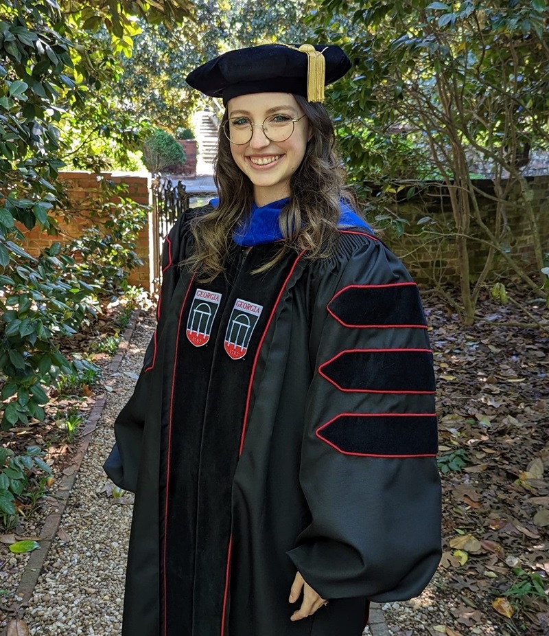 Morgan Dietz standing outside wearing regalia