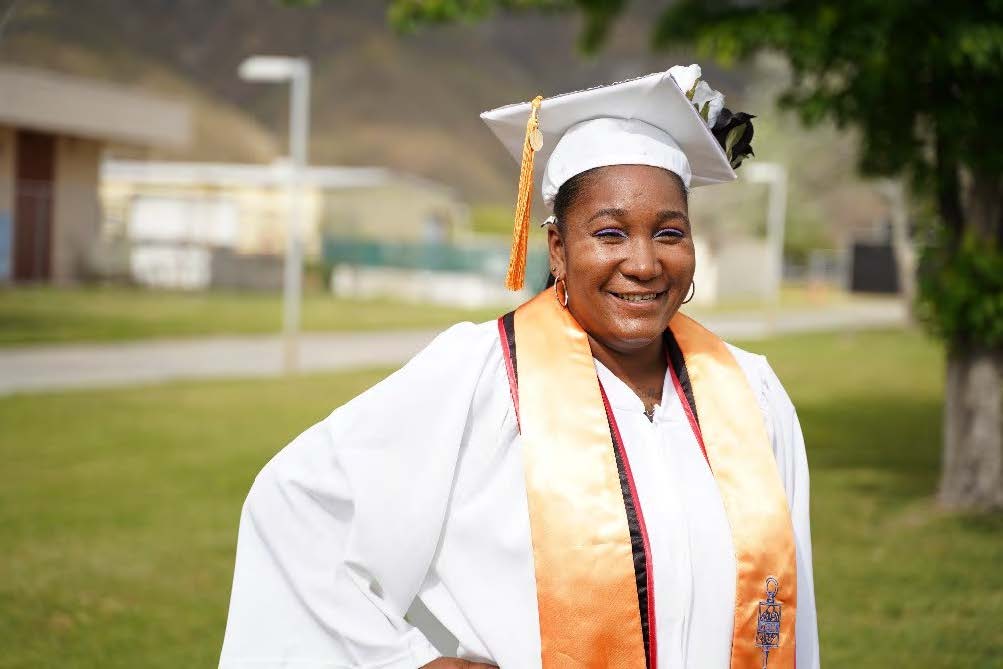 Tichona White wearing her graduation regalia on campus
