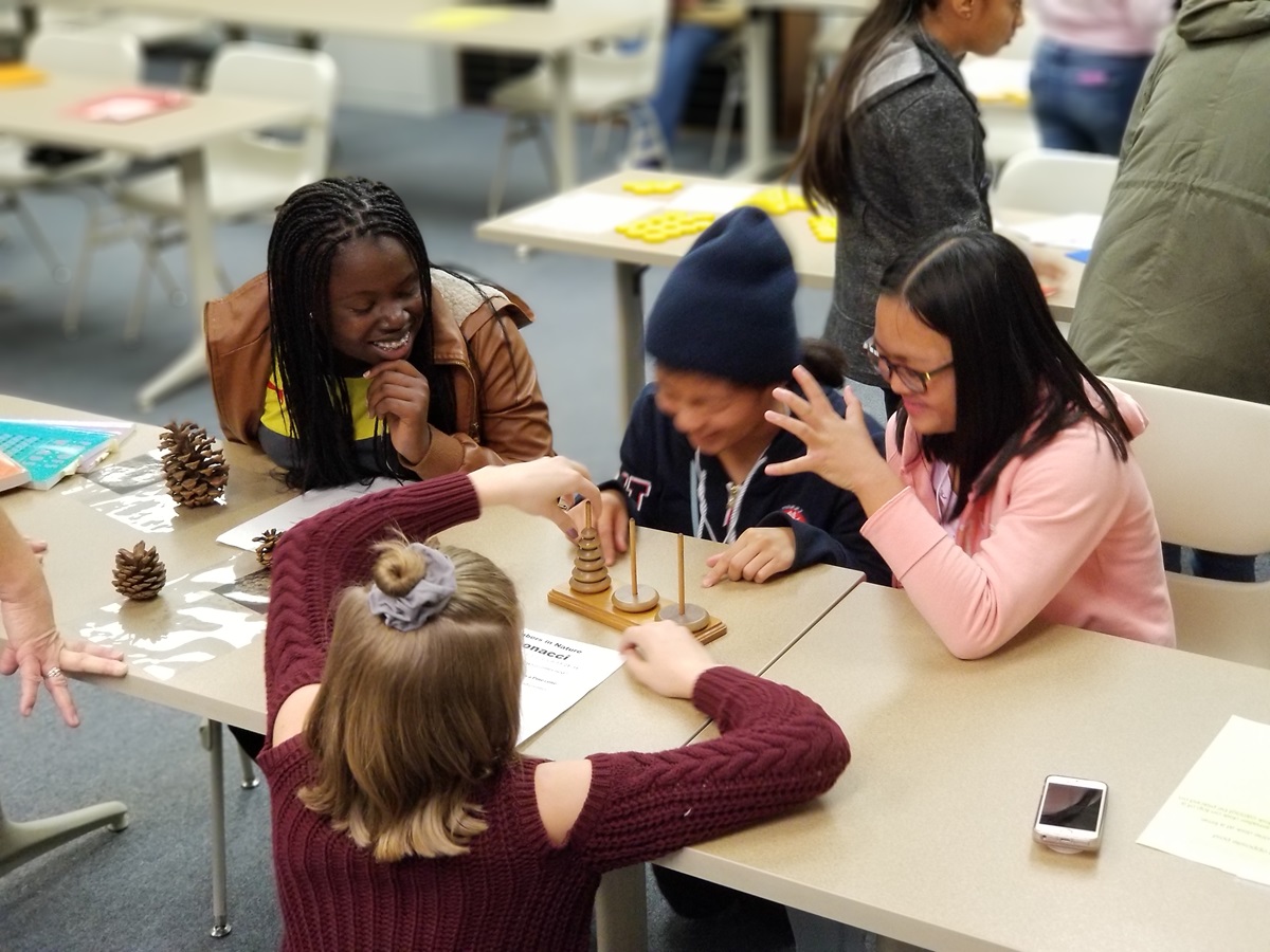A group of 8th grade girls get a giggle out of a math project