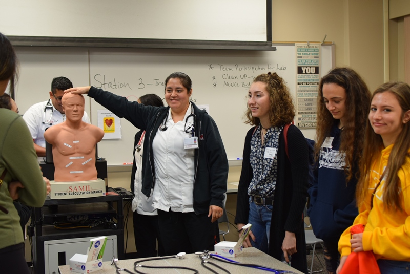 Crystal Ruiz shows high school students some props