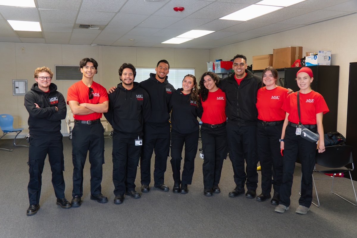 EMT students in uniform smiling for a photo