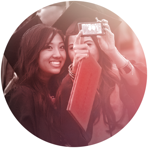 African American and white student taking selfie at graduation